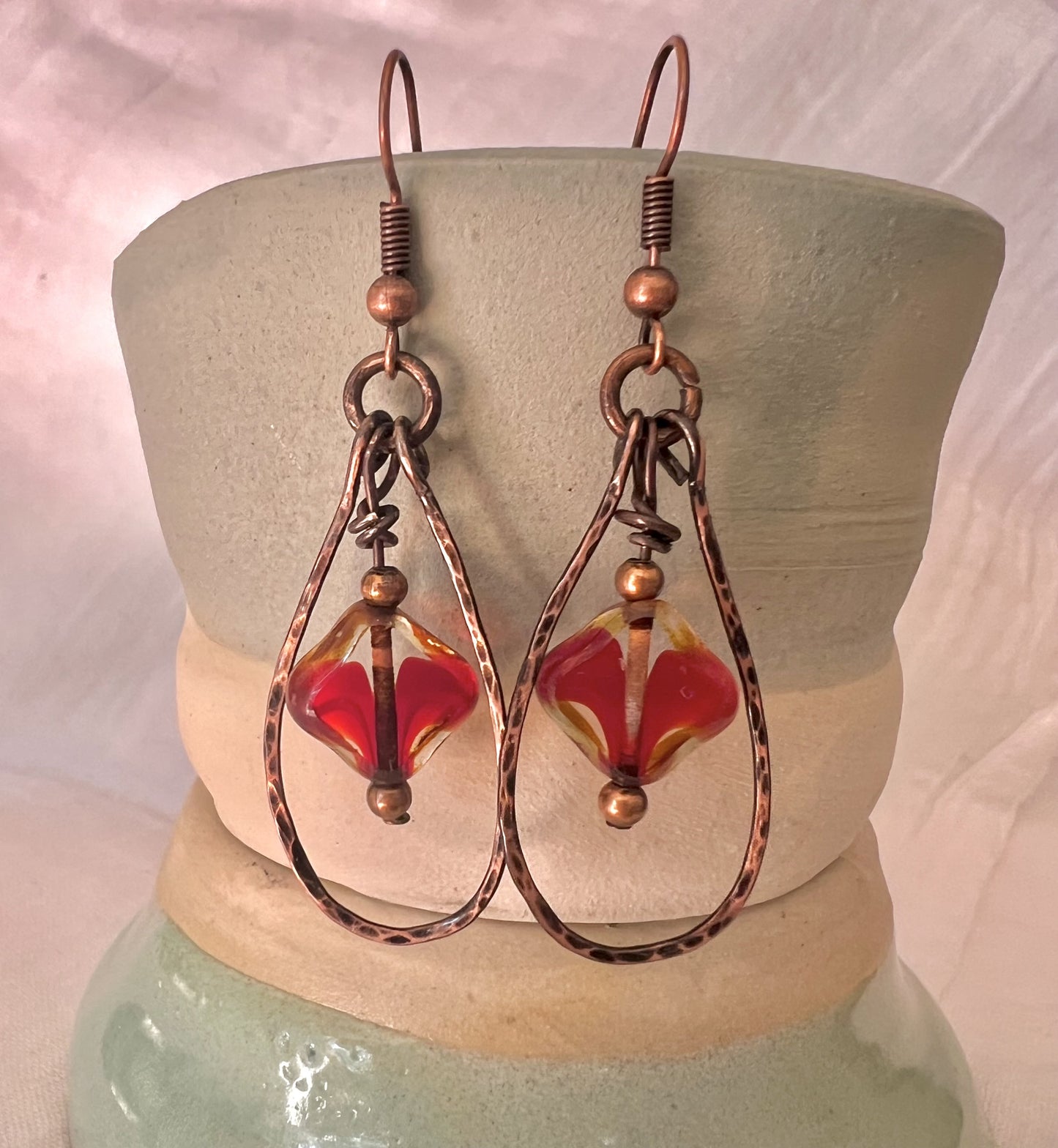 Hand shaped and hand hammered teardrop copper earrings with red Czech glass